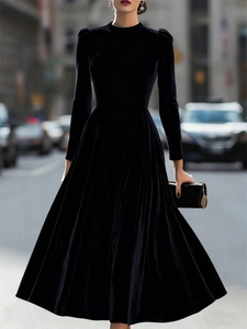Elegant black velvet long sleeve dress with waist cinching and wide flowing hem details