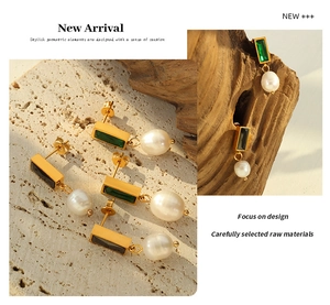 Macro shot of French style earrings with green gemstones and baroque freshwater pearls