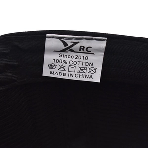Vista macro dell'etichetta interna in 100% cotone con logo e istruzioni su cappello nero