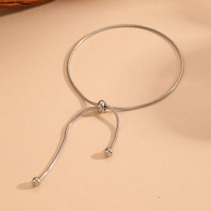 Detail of adjustable silver snake chain bracelet with sliding bolo clasp and metal beads