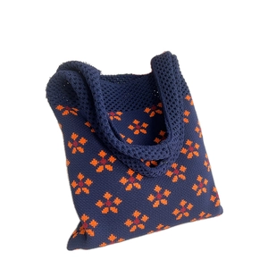 Borsa tote in maglia blu scuro con vivaci motivi floreali arancioni e rossi ricamati