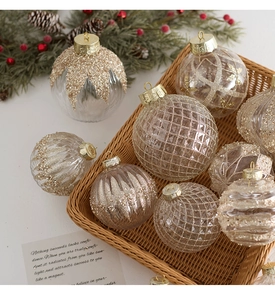 Detail of transparent Christmas balls with gold glitter patterns and metal hanging caps
