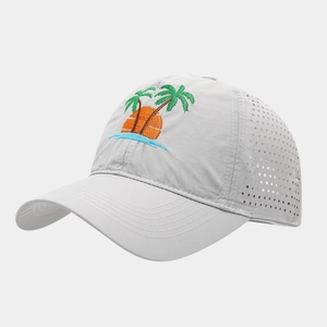 Detail of laser-cut ventilation holes and tropical palm tree embroidery on baseball cap