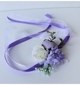 Detail of bridal wrist corsage with white and purple roses and elegant silk ribbons