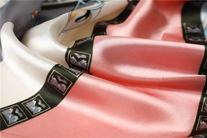 Detailed view of pink and grey satin silk scarf showing smooth texture and floral pattern