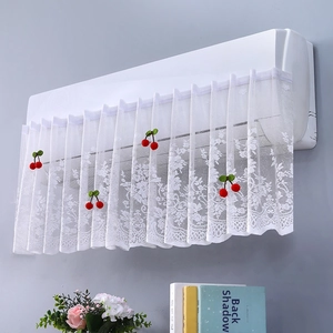 Detail of white lace air conditioner cover featuring red cherry decorative accents
