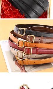 Close-up of slim leather belts with hexagonal gold buckles in various vintage colors