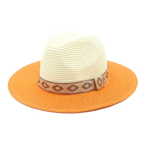 Detail of two-tone woven straw hat with orange brim and ethnic geometric patterned ribbon