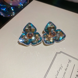 Detailaufnahme der blauen Blumenohrringe mit Diamanten und weißem Kordelrand-Design