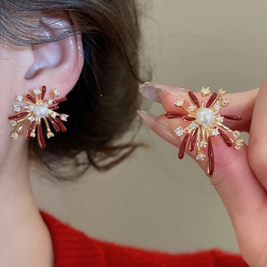 Detail of fireworks design earring with red enamel, pearls and zircon crystals