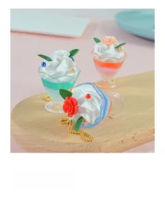 Close-up of mini dessert sundae charms with cream and rose details on wooden tray