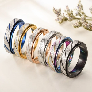Rotating sandblasted metal rings in various colors with a frosted finish and diagonal texture
