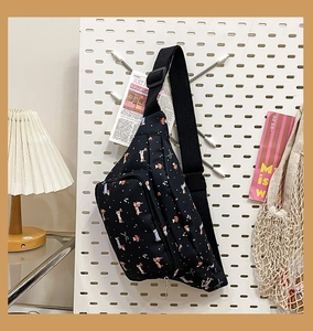 Close-up of black crossbody bag with cute dog prints on a white pegboard background
