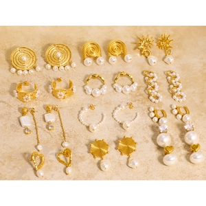 Gold stainless steel earrings collection with pearls and crystals in a flat lay display
