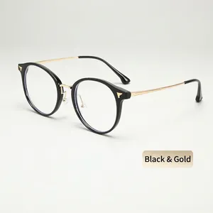Detail of round TR glasses frames in black and gold with decorative metal temples