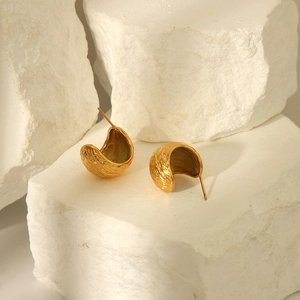 French retro gold C-shaped chunky hoop earrings with textured finish on stone display