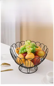 Detailed view of a black iron fruit basket with a floral wire frame and fresh fruits