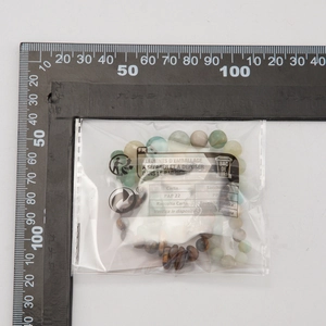 Close-up of tiger eye beaded necklace with size measurement and eco-friendly packaging