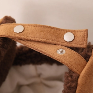 Detailed macro view of the brown faux suede material and silver snap buttons on child hat