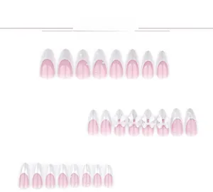 Dettaglio di unghie finte rosa con fiocchi 3D bianchi e perle in raffinato stile francese