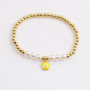 Bracelet élégant en perles dorées avec perles blanches et pendentif œil jaune