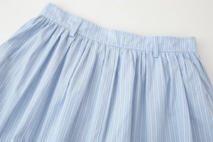 Close-up of blue and white vertical striped skirt with pleated waist and belt loops
