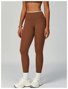 Detail der braunen High-Waist Yoga-Leggings mit stylischem weißem Kontrast-Bundbesatz
