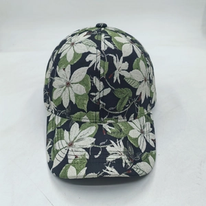 Detail of floral baseball cap featuring white flowers and green leaves on dark fabric