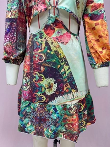 Detail of colorful landscape print dress with waist cut-out and metallic ring