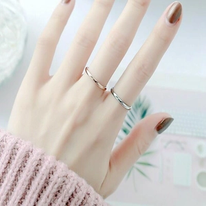 Detailed close-up of slim gold and silver stainless steel rings worn on fingers