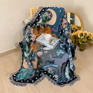 Close-up of bohemian unicorn knit throw with moon patterns and decorative fringe details