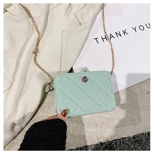 Detail of light green PVC jelly bag with quilted texture and flower lock buckle