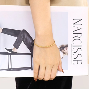 Minimalist 18K gold plated stainless steel C-shaped cuff bracelet worn on a wrist