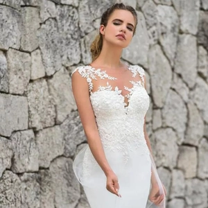 Elegante abito da sposa a sirena bianco con applicazioni in pizzo e collo velato