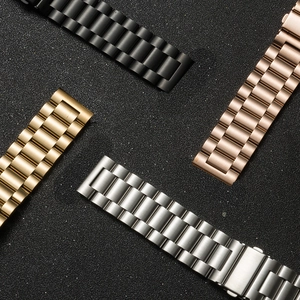 Cinturini in metallo per orologi in nero, oro, oro rosa e argento su sfondo nero opaco