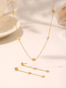Detail view of 18K gold-plated floral jewelry set with necklace and drop tassel earrings