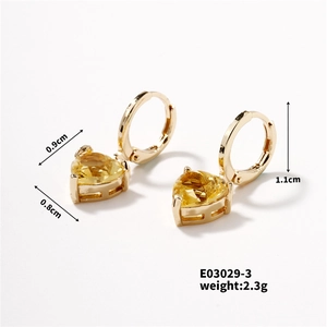Dettaglio orecchini a cerchio dorati con gemme gialle a cuore, altezza 1,1 cm e 2,3 g