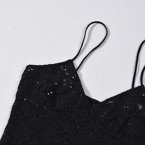 Detalle de tela de encaje floral negro con lentejuelas plateadas y tirantes finos