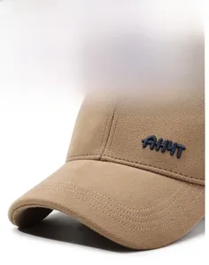 Detail of embroidered navy AHMT letters on a khaki textured winter baseball cap