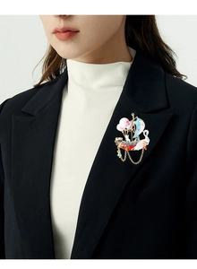 Detail of sailboat brooch with colorful enamel and chain on black suit lapel