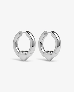 Macro detail of high-polish silver hoop earrings with 3D heart-shaped pendant design