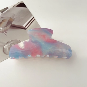 Macro shot of large pink and blue marble resin hair claw clip with glitter finish