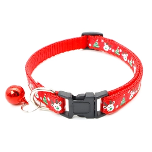 Detail of red Christmas pet collar with deer print, plastic buckle and metal bell