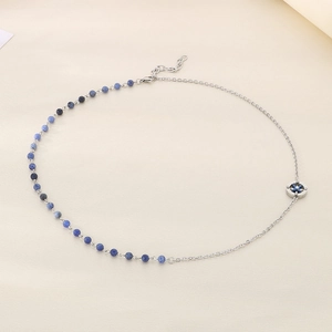 Detail of blue turquoise beads and silver chain necklace with a star compass pendant