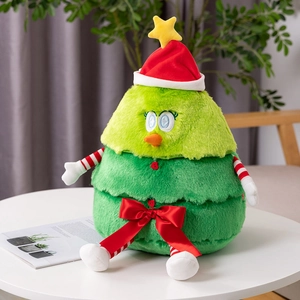 Detail of green Christmas tree plush toy with a red hat and bow on a white table