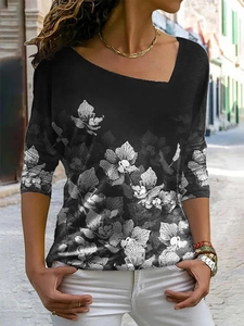 Detail van dames top met lange mouwen, witte bloemenprint en asymmetrische halslijn