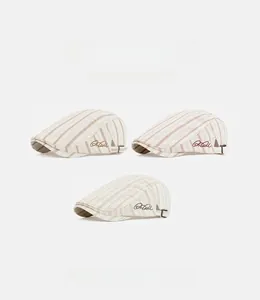 Detailed close-up of striped British style beret caps with embroidery and metal buckle