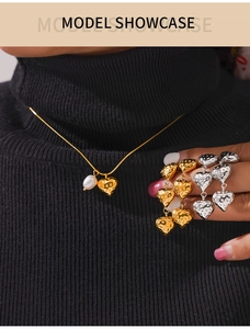 Détail du collier à pendentif cœur doré et des boucles d'oreilles sur un modèle