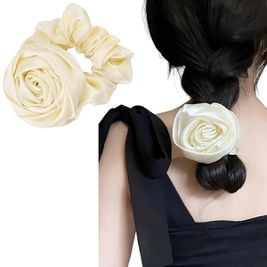 Detailed view of satin floral scrunchies in cream and white with silk-like texture