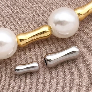 Dettaglio ravvicinato di perline a forma di bambù placcate oro 18k e perle lucide